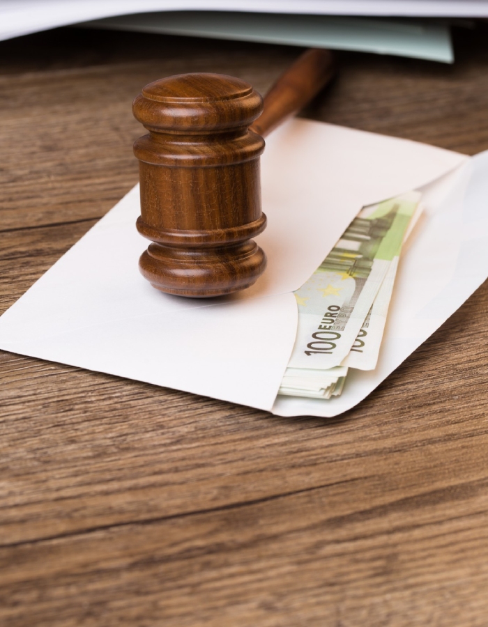 Marteau de juge avec des billets illustrant la pension alimentaire